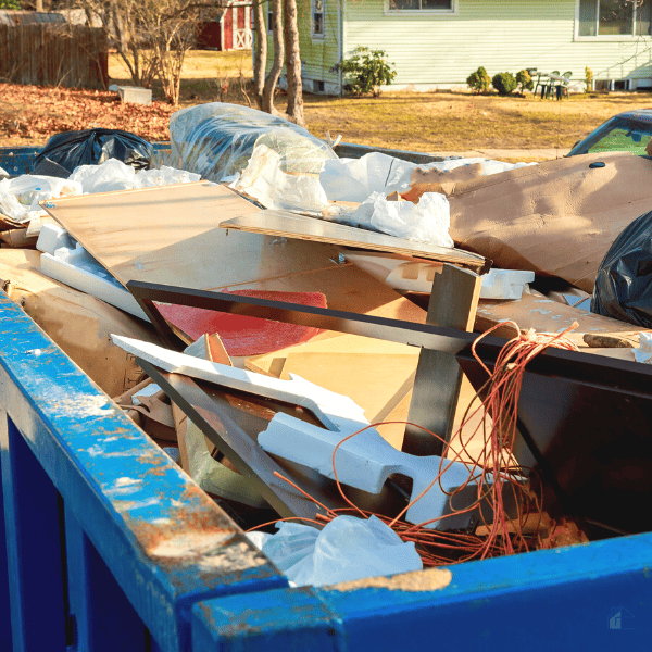 Container over flowing dumpster full of stuff.