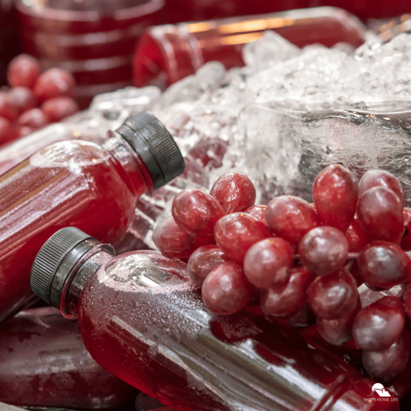 An image of bottled grape juice and grapes on the side.