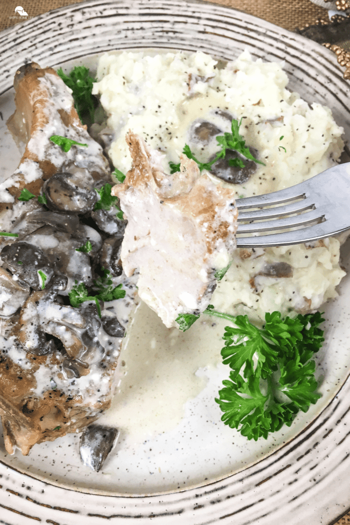 Slow Cooker Thick-Cut Bone-In Pork Chops being scooped by a fork