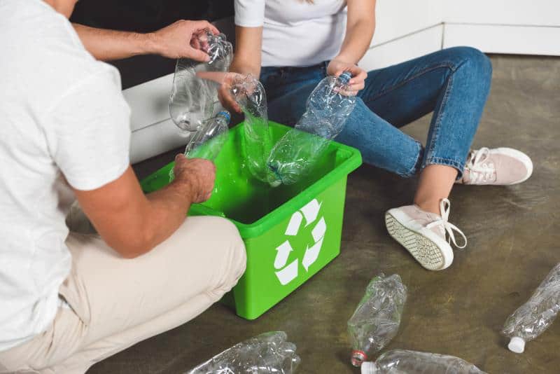 couple recycling plastic bottles