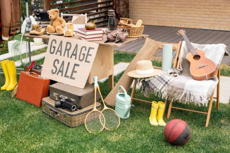 garage sale with various items like toys, books, and a guitar