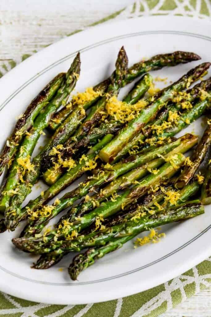 asparagus with lemon zest on white plate