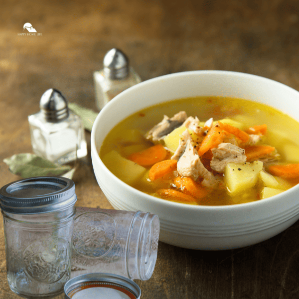 a bowl of soup with jar beside it