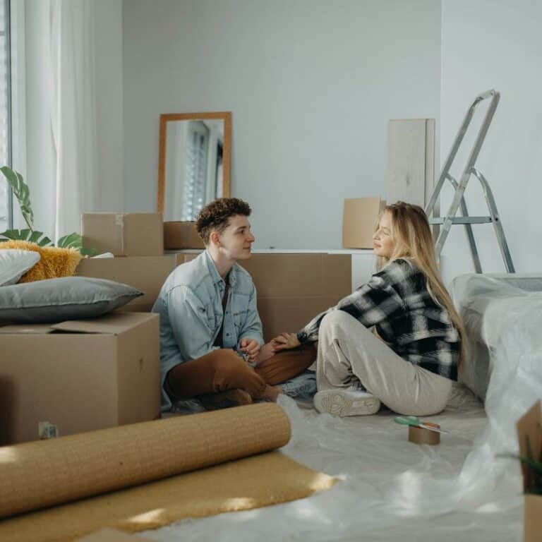 couple sitting on floor surrounded by boxes