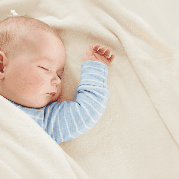 Baby sleeping covered with soft white blanket