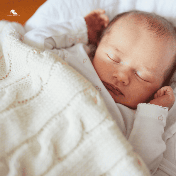 Newborn Baby Sleeping under Knitted Blanket
