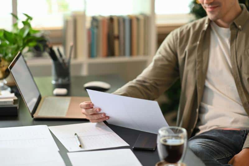 man looking at documents in home office