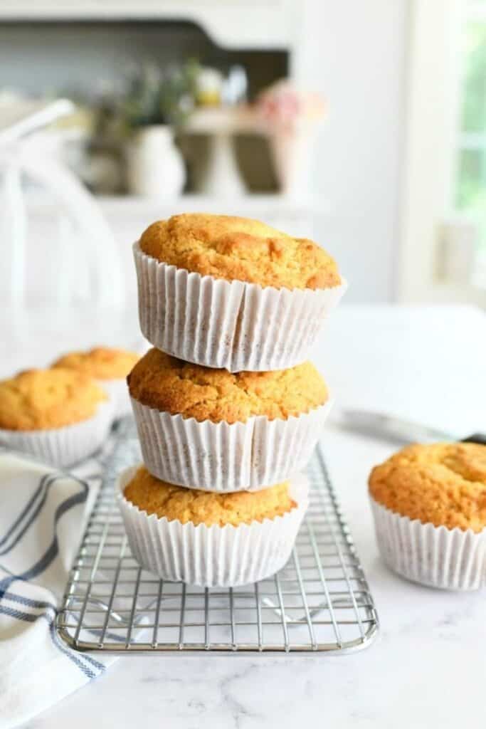 jumbo bakery style cornbread muffins stacked in group of 3 with other muffins off to the sides