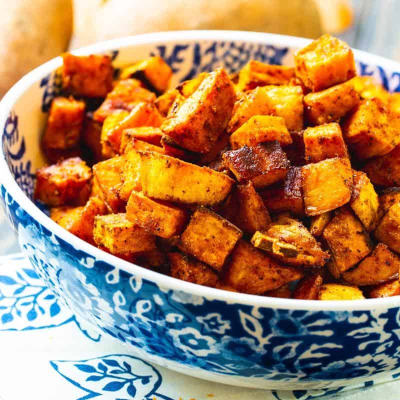 sweet and spicy sweet potatoes in a blue and white bowl