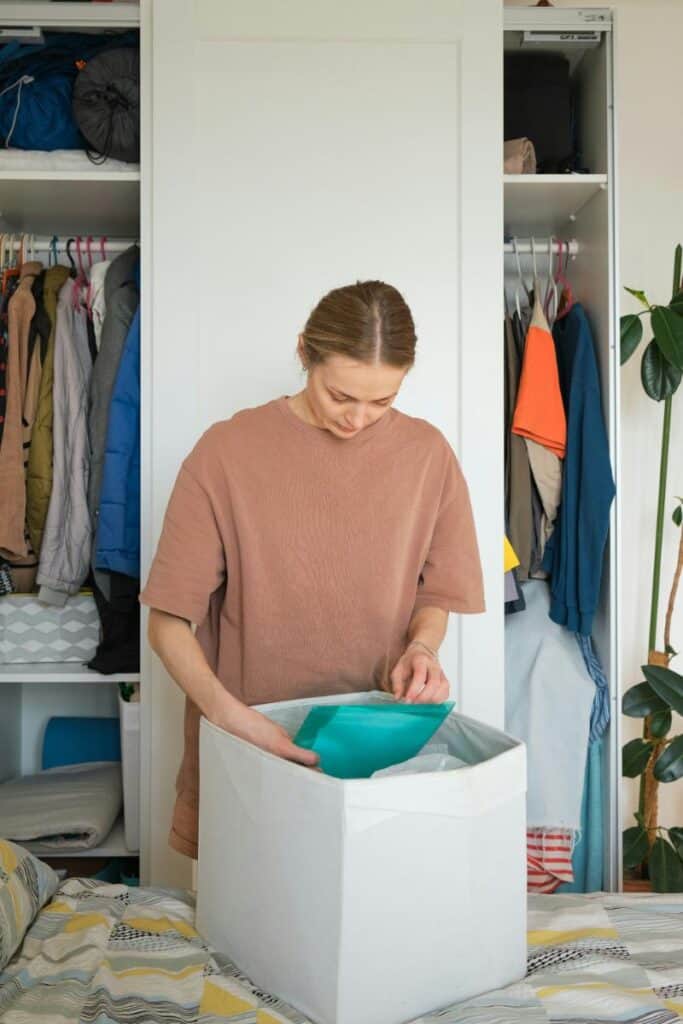 woman placing items in a storage cube as she declutters