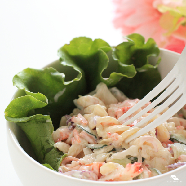An image of crab pasta salad over a bed of lettuce.