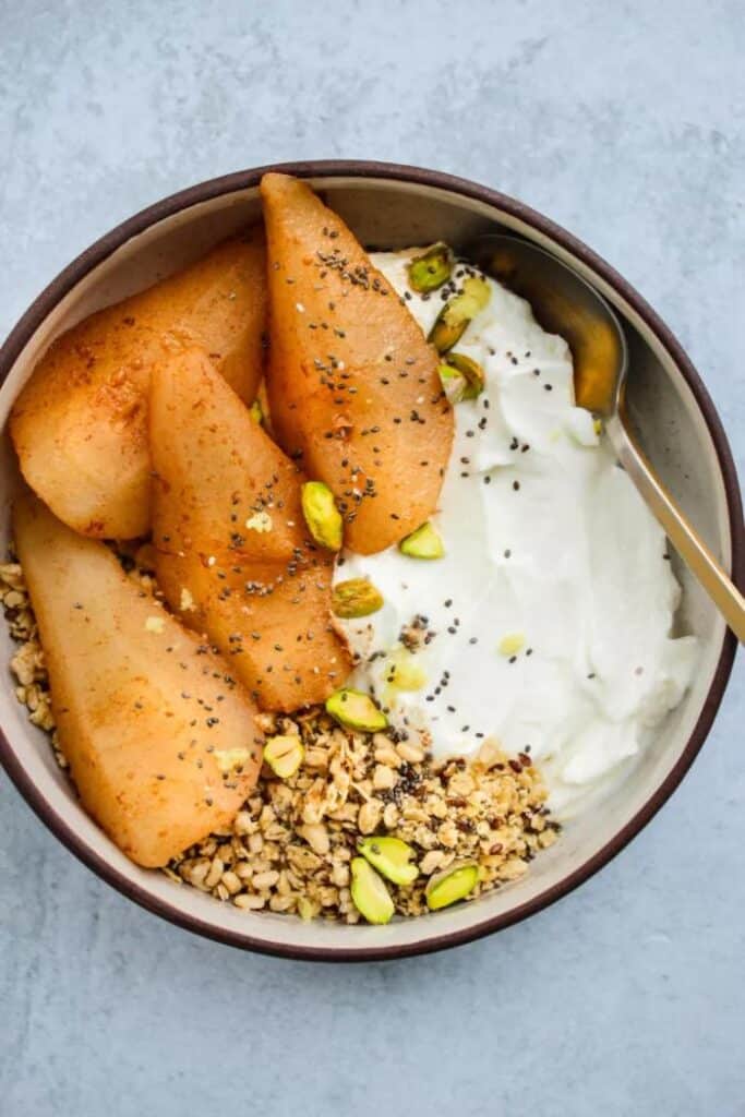 yogurt bowl with honey poached pears and pistachios