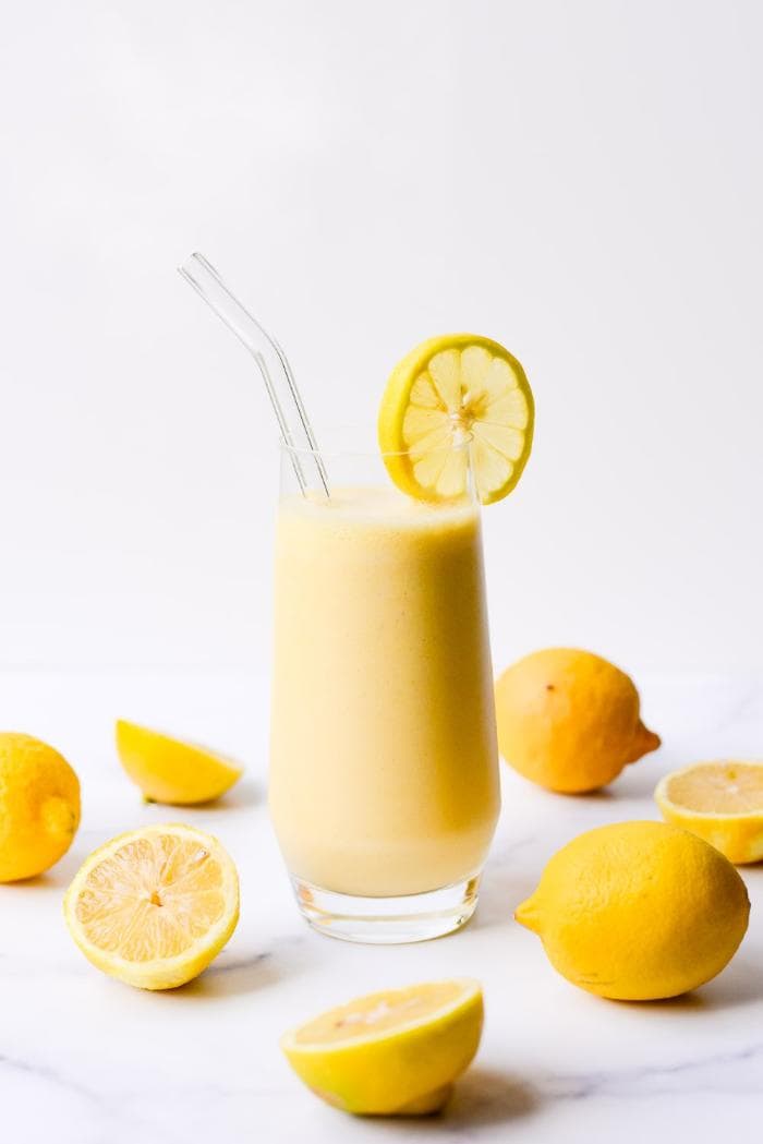 lemon smoothie in glass with lemon garnish