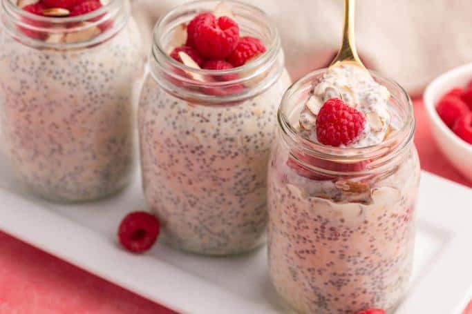 raspberry overnight oats in mason jars on a white plate