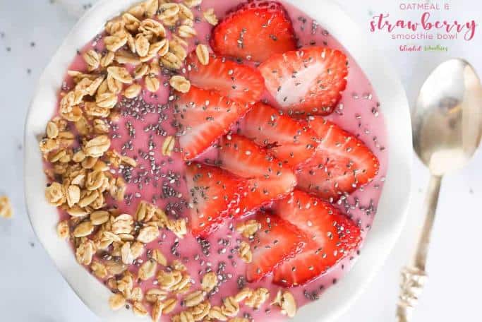 smoothie bowl made with oatmeal to thicken and topped with granola, fresh strawberries, and seeds