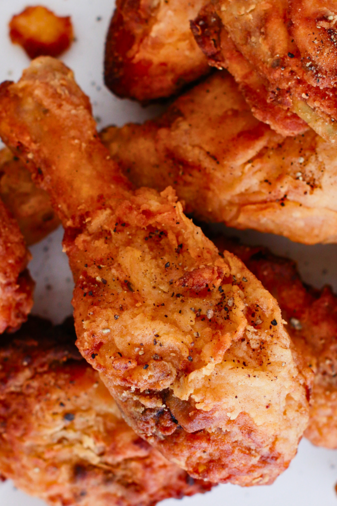 Close-up of crispy fried chicken drumsticks with a golden, crunchy coating, perfect for an easy fried chicken recipe or homemade Southern fried chicken dinner.