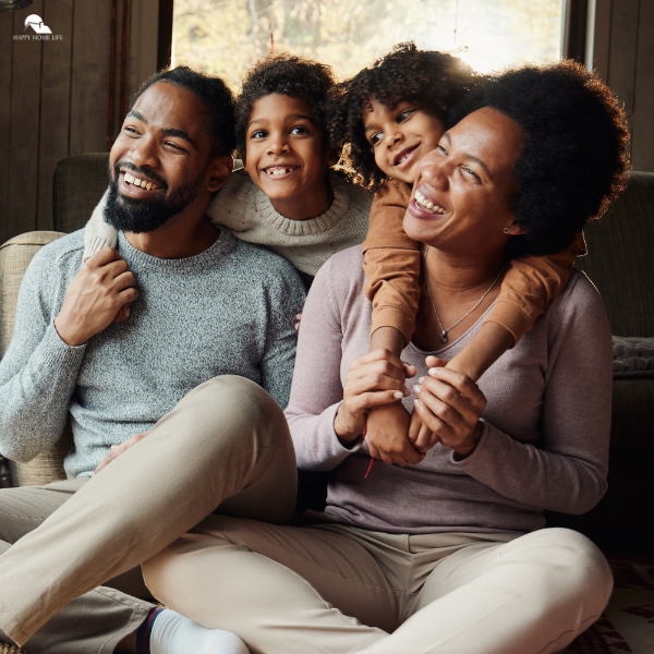 A joyful family sitting together in a cozy space, reflecting homemaking goals that nurture connection and happiness at home.